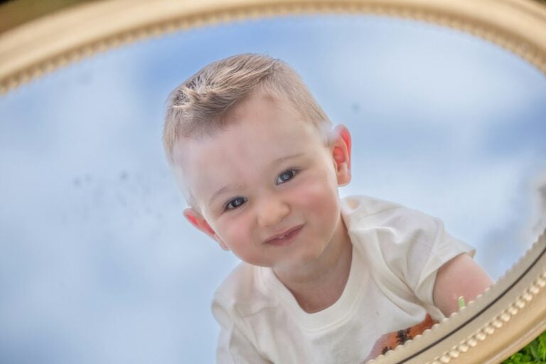 A happy baby looking into a mirror