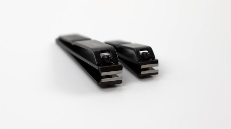 Two black nail clippers on a white background
