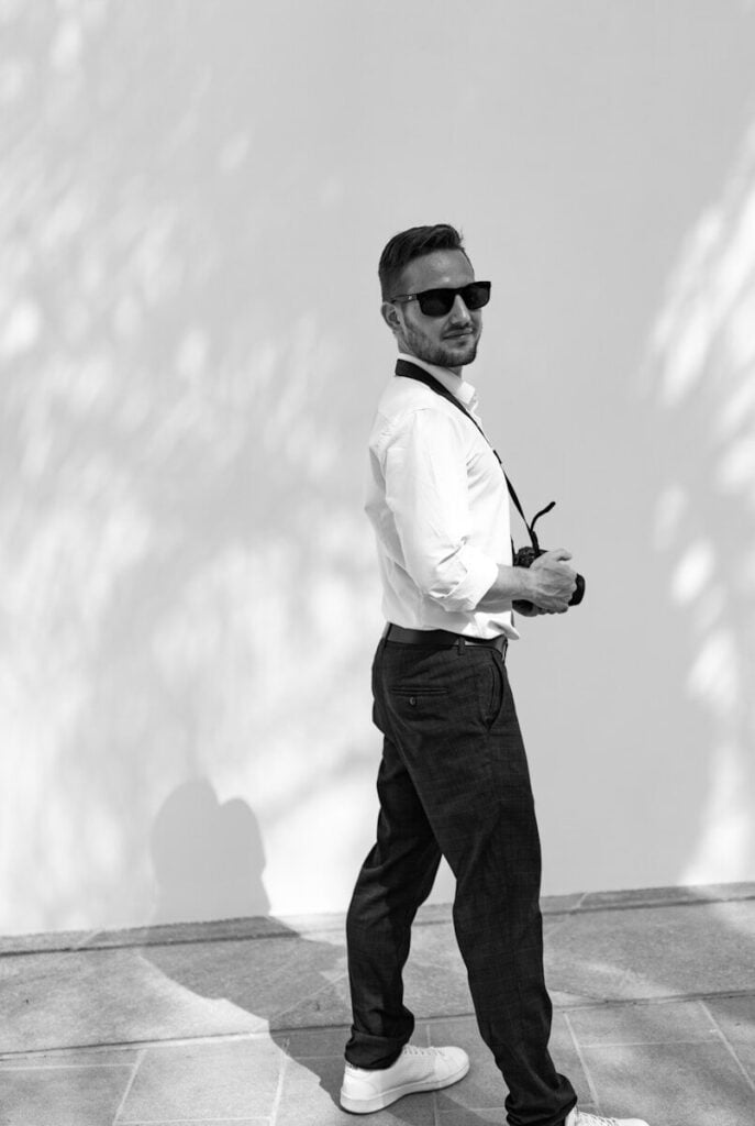 a man wearing sunglasses and holding a microphone