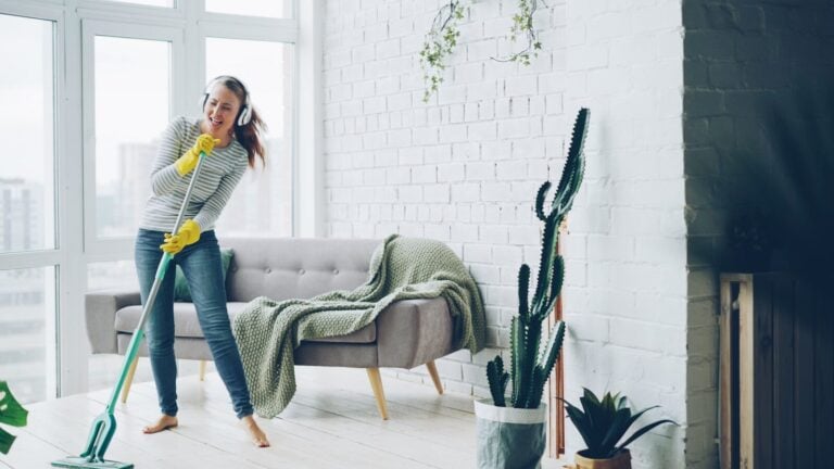 Woman singing and dancing while vacuuming a room